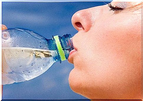 A woman drinks water from a bottle