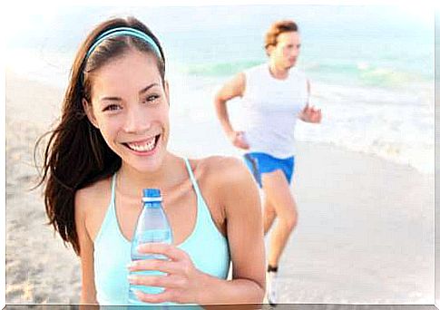 Athlete on the beach with a water bottle in hand