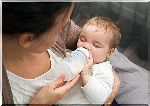 The mother feeds the baby with a baby bottle