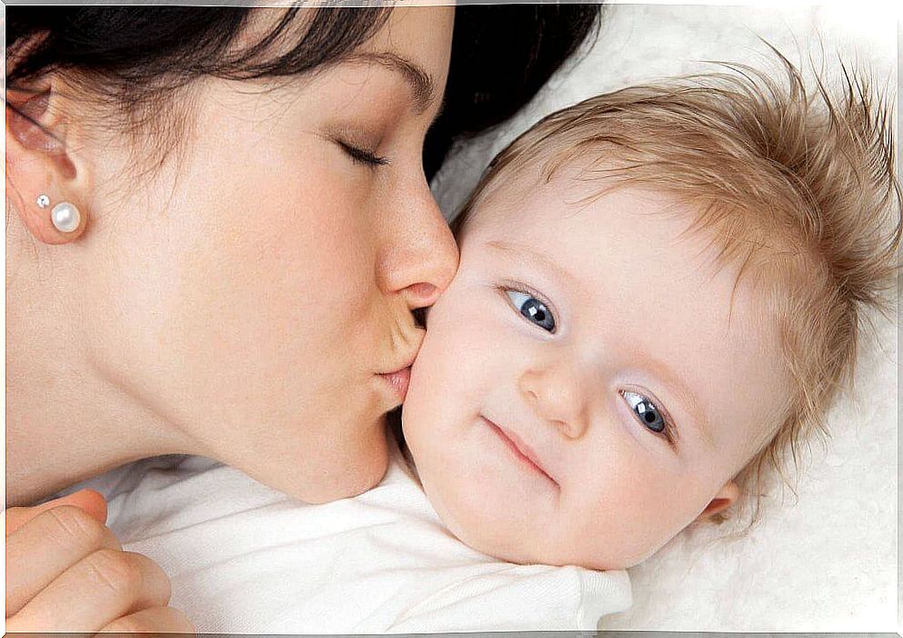 mother gives her baby a kiss